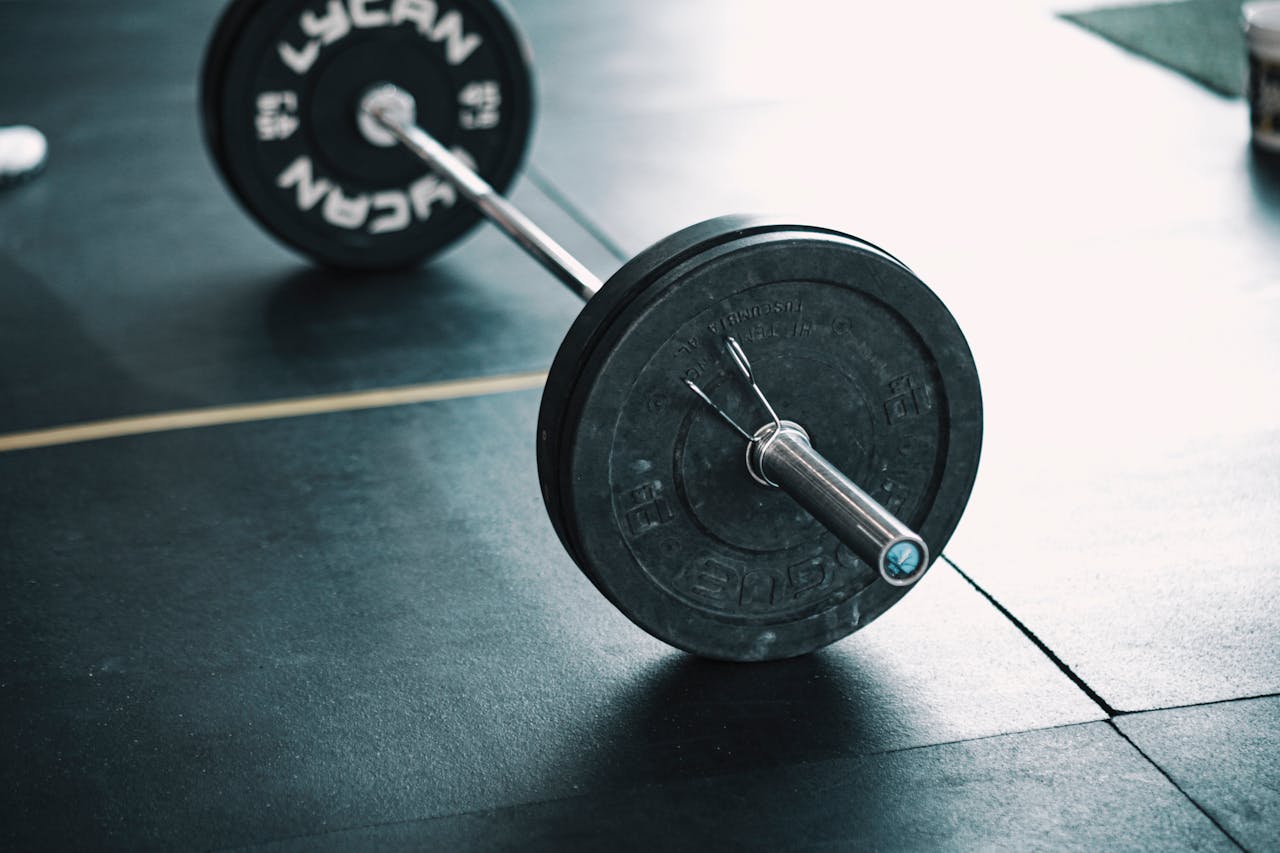 why-choose-us A detailed image of a barbell resting on a gym floor, perfect for fitness themes.